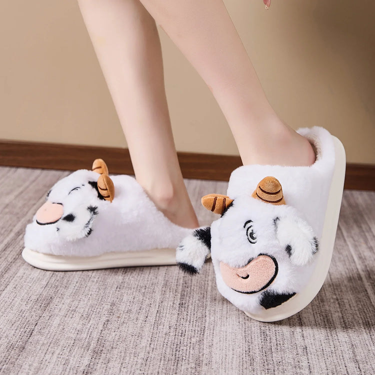 White plush cow slippers with cartoon face, thick sole, cozy fit, worn indoors on carpet