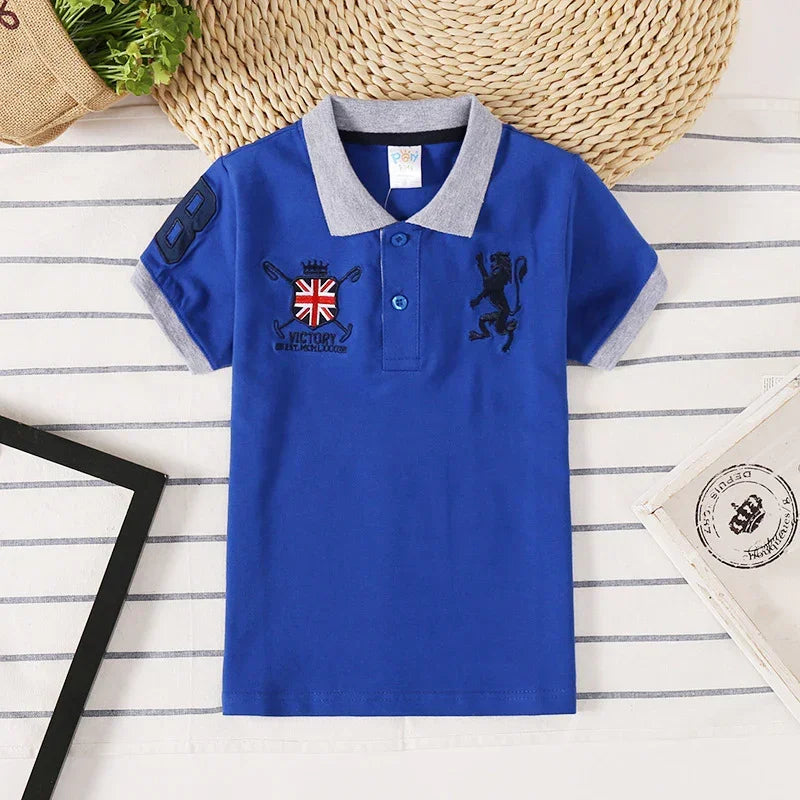 Blue short-sleeve polo shirt with grey collar, embroidered crest, lion patch, and number detail.