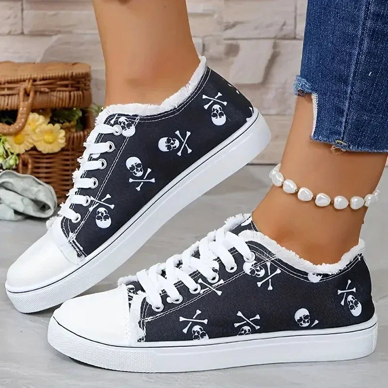 Black canvas sneakers with white skull prints, frayed edges, and lace-up design, casual fit