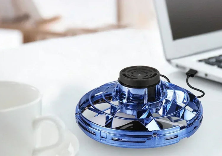 Blue metallic USB-powered desk fan with circular grille, placed next to a laptop.