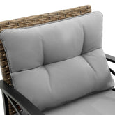 Light gray padded outdoor chair cushion with woven rattan backrest and metal armrests