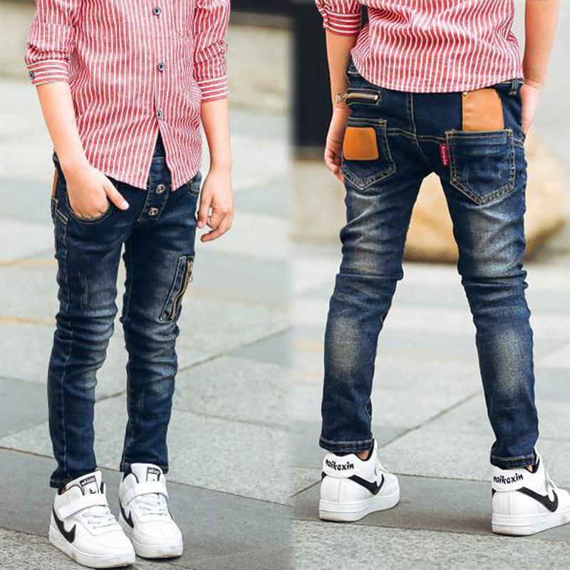 Child in slim fit blue distressed jeans with tan pocket patches and red striped shirt