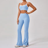 Woman wearing light blue fitted crop top and high-waisted flared leggings with white accents