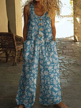 Sleeveless blue floral wide-leg jumpsuit with wooden buttons, relaxed fit, side pockets.