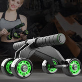 Woman in a gray and black sports bra holding a black and green ab roller with four wheels