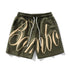 Olive green streetwear shorts with beige graphic text, drawstring waist, relaxed fit