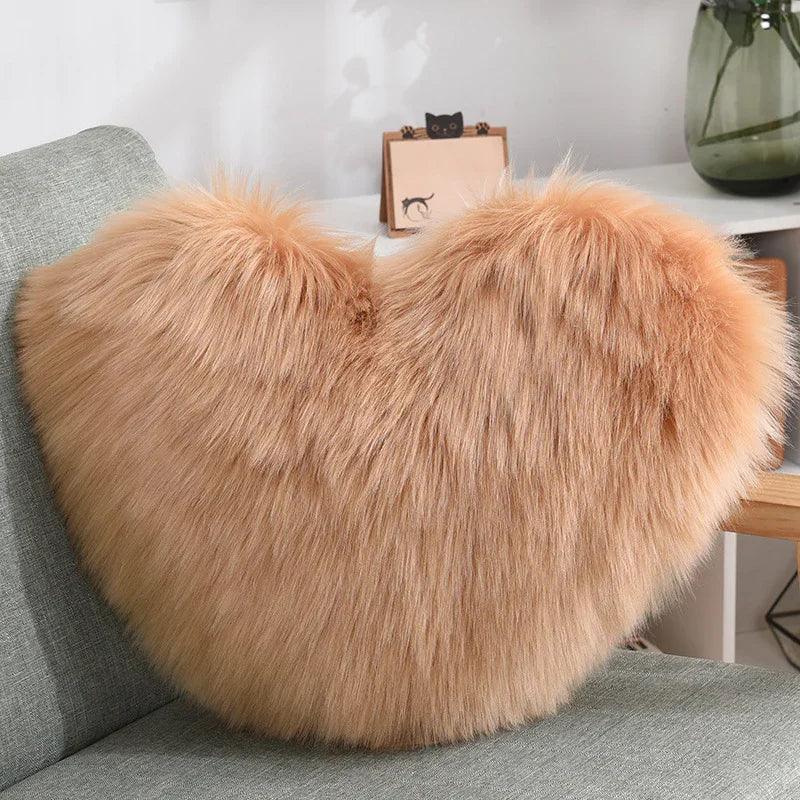 Heart-shaped faux fur pillow in light brown, fluffy texture, on modern sofa