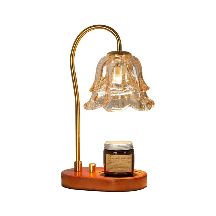 Vintage glass flower lamp with gold metal stem and wooden base, holding a candle jar