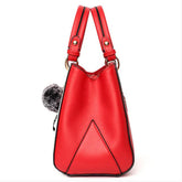Red faux leather handbag with double handles and geometric stitching, side view