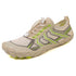 Beige athletic sneaker with green and gray geometric accents, mesh upper, and flexible fit