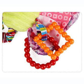 Colorful baby toy rings attached to soft patterned fabric, featuring red and orange beads.
