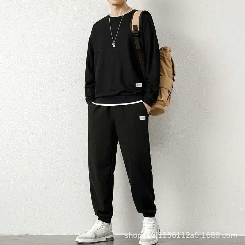 Man wearing black relaxed fit streetwear sweatshirt and jogger pants set, white sneakers