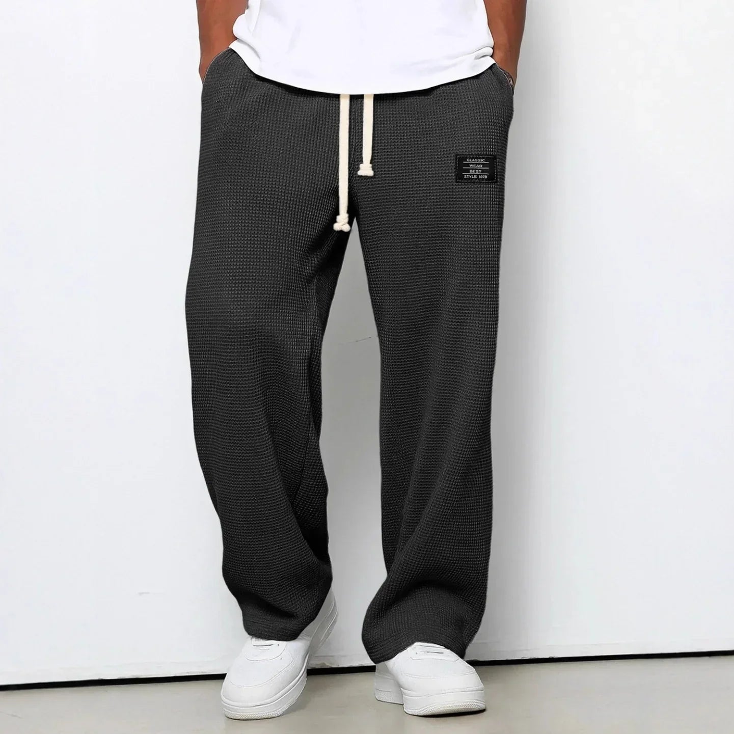 Loose fit black textured waffle knit pants with drawstring waist and patch detail