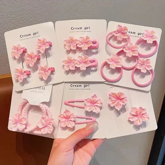 Assorted pink and white flower hair clips and elastic bands on display cards, cute floral accessories