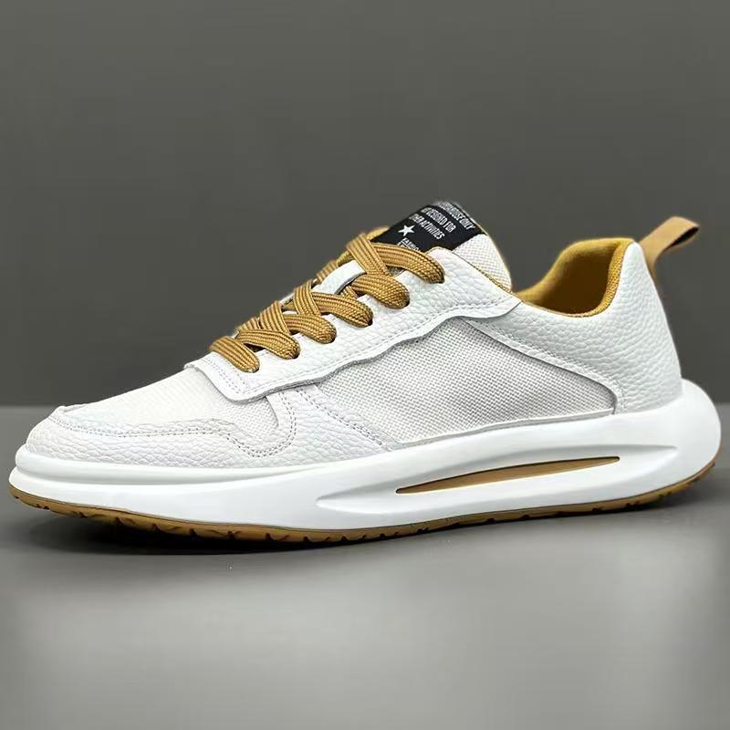White low-top sneaker with textured leather panels, mesh sides, and tan laces on grey background