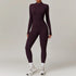 Woman wearing fitted long sleeve dark purple jumpsuit with front zipper, athletic style