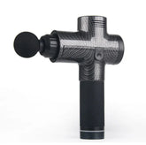 Black carbon fiber massage gun with round head and ergonomic grip on white background