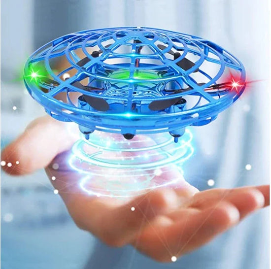Blue futuristic toy drone with LED lights hovering above an open hand indoors.