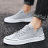 Light gray suede low-top sneakers with white chunky soles, modern casual streetwear style