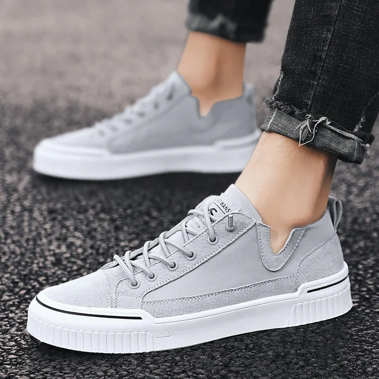 Light gray suede low-top sneakers with white chunky soles, modern casual streetwear style