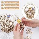 Hands assembling a wooden 3D gear puzzle with colorful crystal balls, DIY mechanical model.