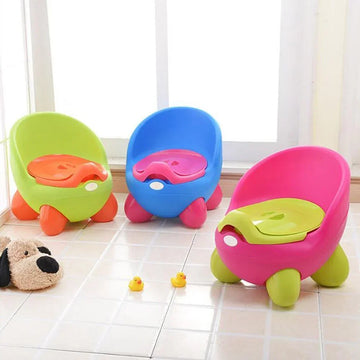 Colorful plastic toddler potty chairs with rounded seats and lids on tiled floor