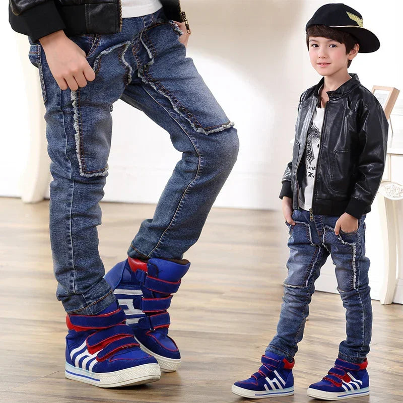 Boys wearing blue distressed skinny jeans, faux leather jackets, and high-top sneakers