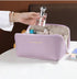 Light purple zippered cosmetic bag with smooth finish, holding toiletries on a white table