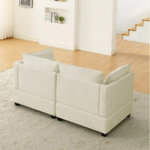 Modern cream fabric sofa with boxy design and plush cushions, set in a minimalist living room