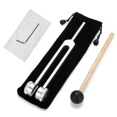 Silver metal tuning fork with weighted ends, mallet, hex key, and cleaning cloth on black pouch