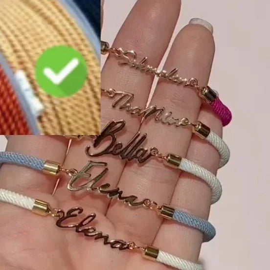 Hand holding multiple personalized rope bracelets with gold metal nameplates in assorted colors.