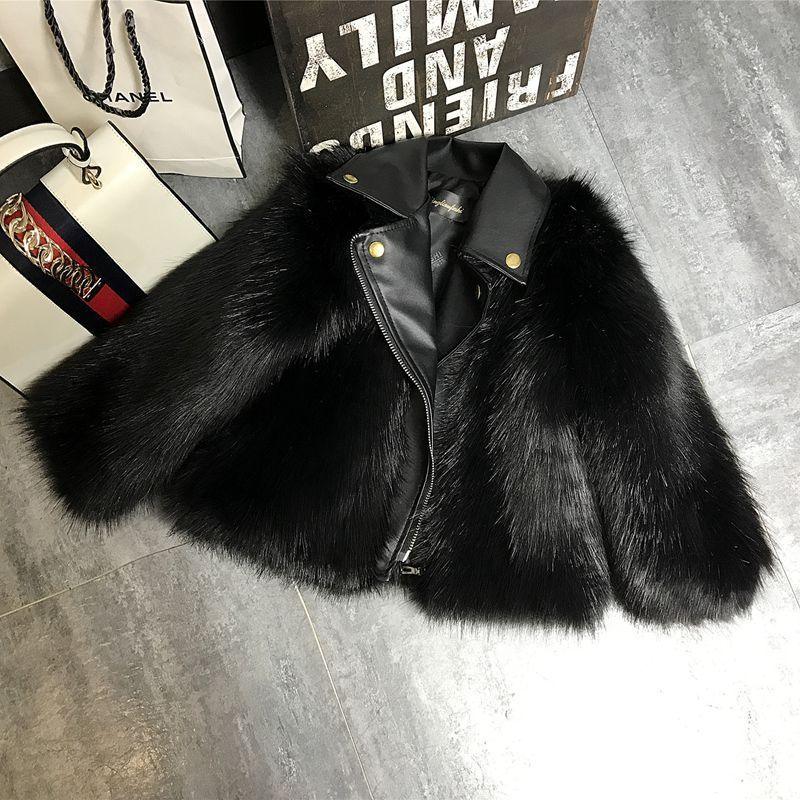 Black faux fur jacket with leather collar, relaxed fit, streetwear style on gray floor