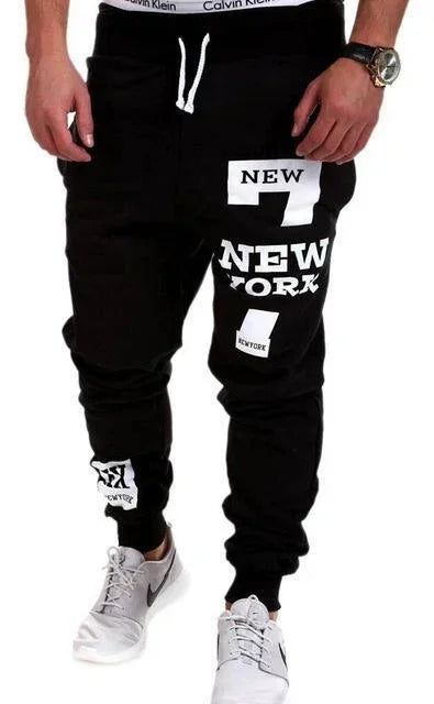 Men's black streetwear jogger pants with bold white New York graphic print, slim fit