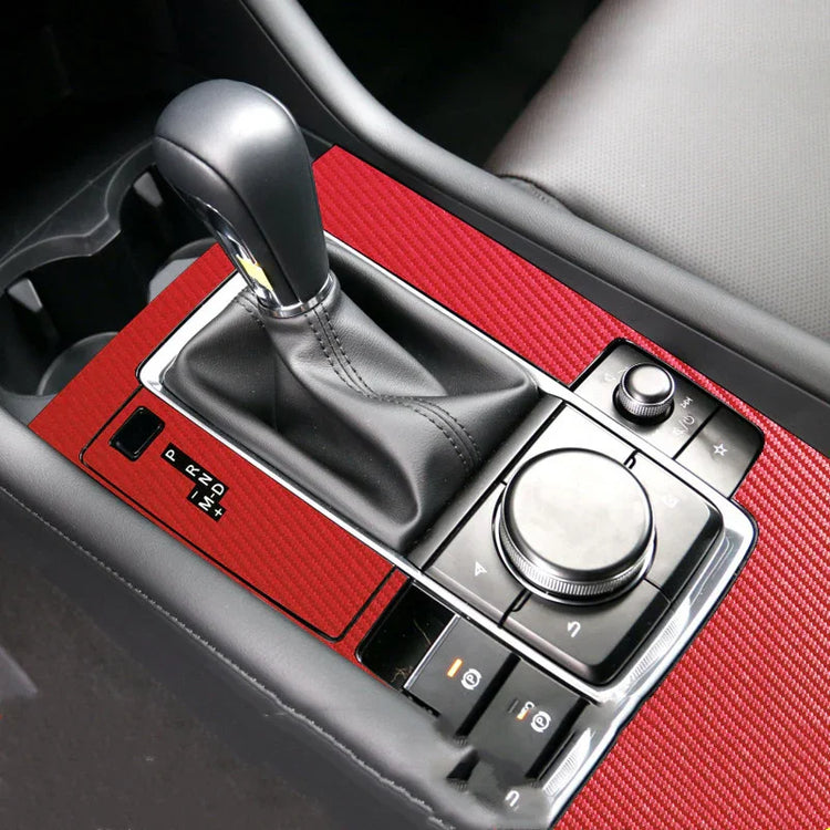 Red textured car center console trim with black leather gear shift and silver accents