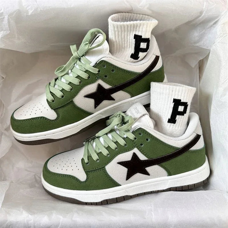 Green and white low-top suede sneakers with black star detail and ribbed white socks