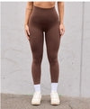 Brown high-waisted ribbed leggings, form-fitting stretch fabric, streetwear style with white socks and sneakers