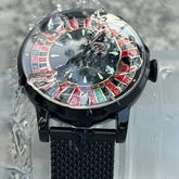 Black metal mesh strap watch with roulette wheel dial under running water, waterproof design