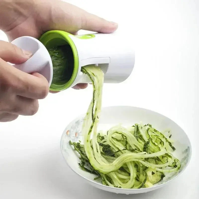 Handheld vegetable spiralizer making zucchini noodles over a bowl, white and green color