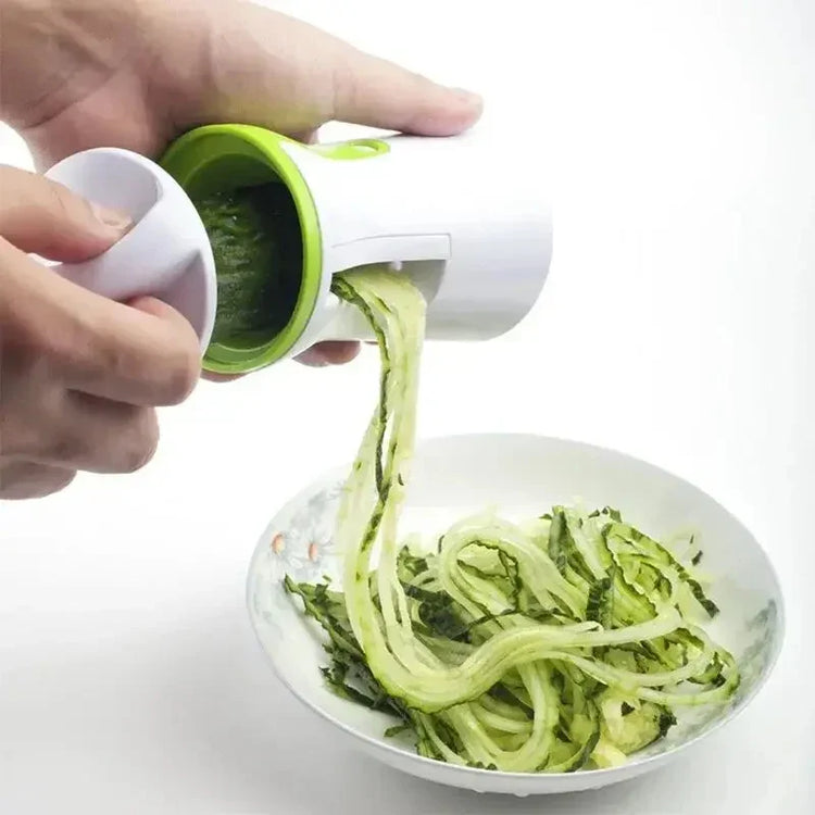 Handheld vegetable spiralizer making zucchini noodles over a bowl, white and green color