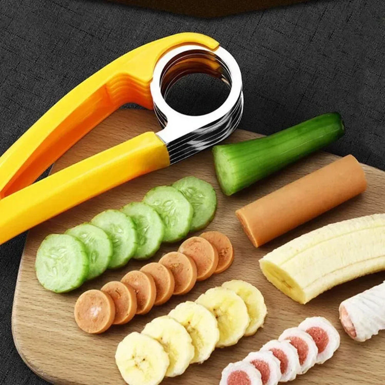 Yellow and silver food slicer with sliced cucumber, banana, sausage on wooden board