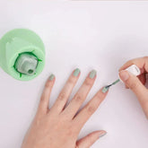 Person applying pastel green nail polish with silicone bottle holder on white background