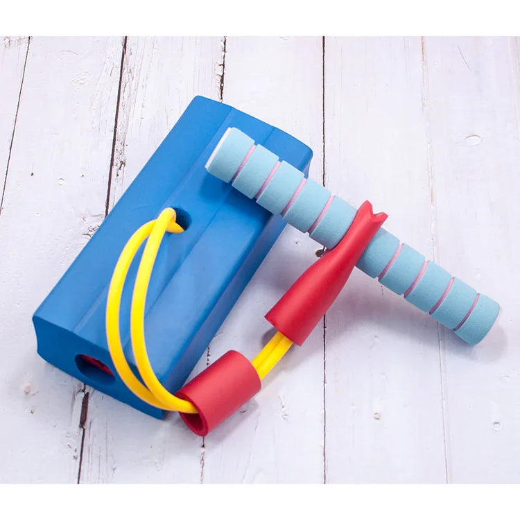 Blue foam pedal fitness resistance band with yellow elastic tubes and cushioned handles on wood floor