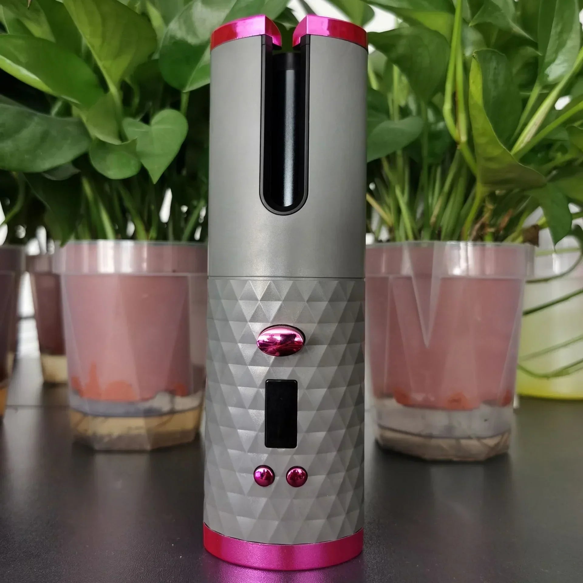 Futuristic cordless hair curler with diamond-textured grey body and pink accents