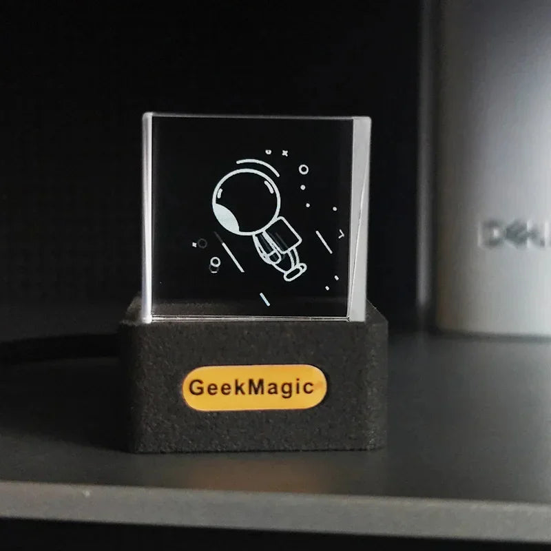 Clear acrylic block with minimalist astronaut engraving on black base, modern tech decor