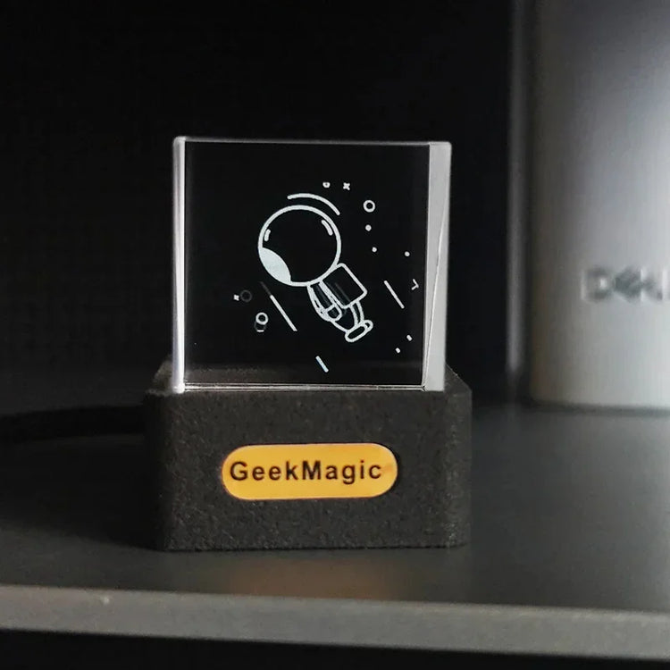 Clear acrylic block with minimalist astronaut engraving on black base, modern tech decor