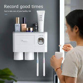 Woman in casual loungewear using modern wall-mounted bathroom organizer with toothbrushes and cups.