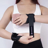 Woman wearing black adjustable wrist support straps over a white sports bra, athletic fit