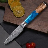 Damascus steel kitchen knife with blue resin and wood handle on cutting board