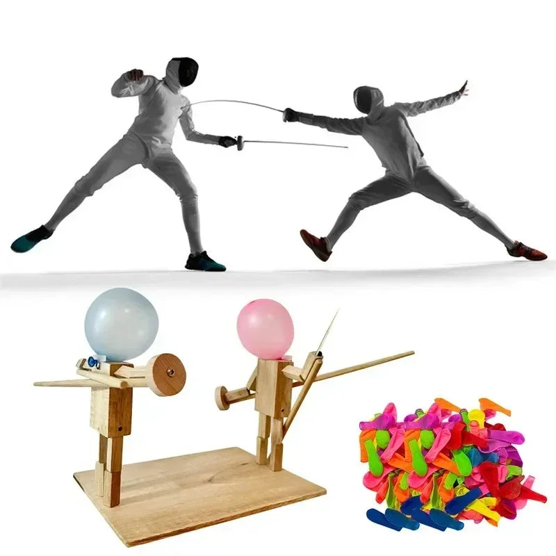 Two people in full white fencing outfits with masks and gloves, and a wooden tabletop fencing game set with colorful balloons and accessories.