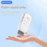 Palm-sized white handheld gadget with grey brush, compact travel cleaning tool